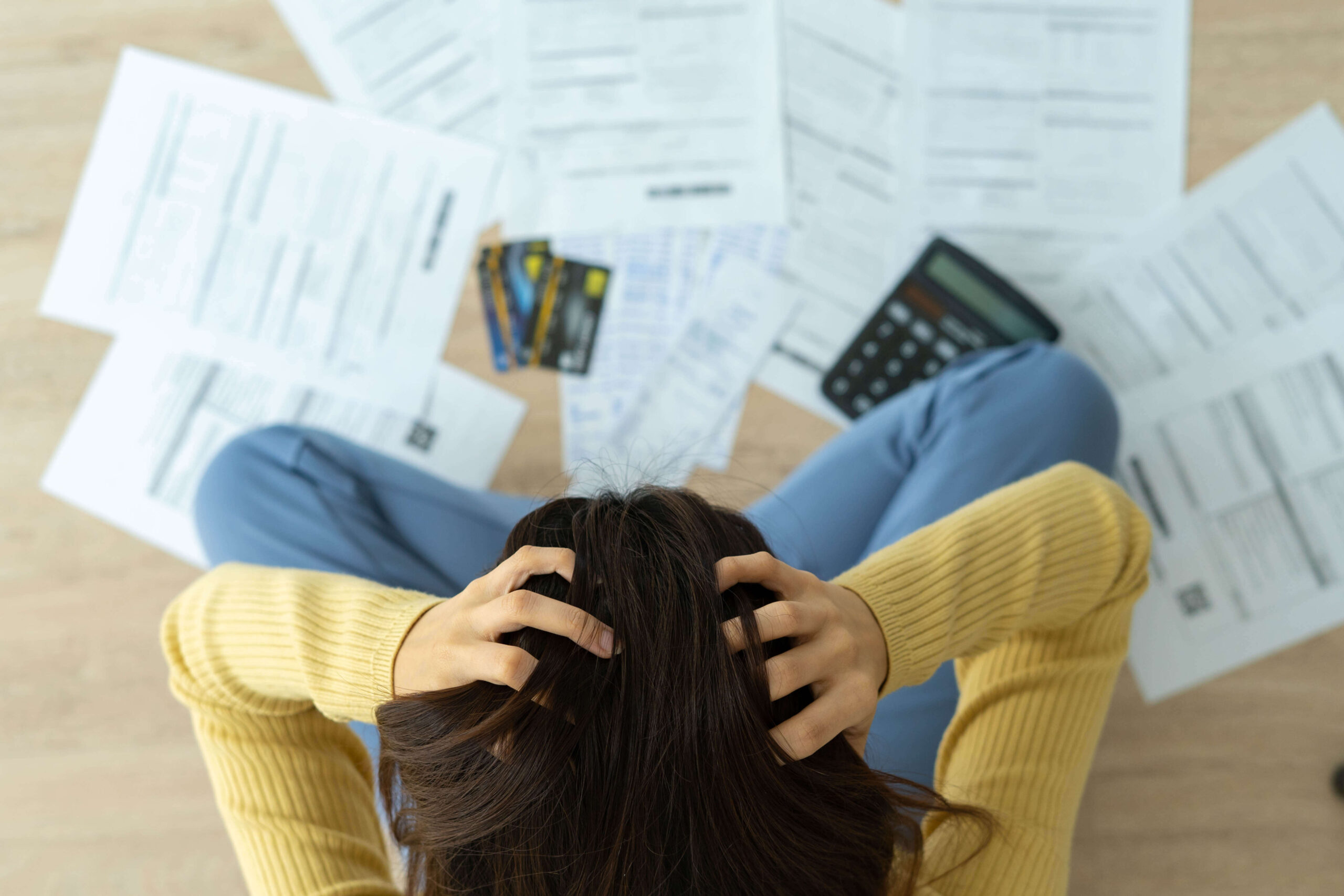 woman with hands on her head looking at invoices - mr electric